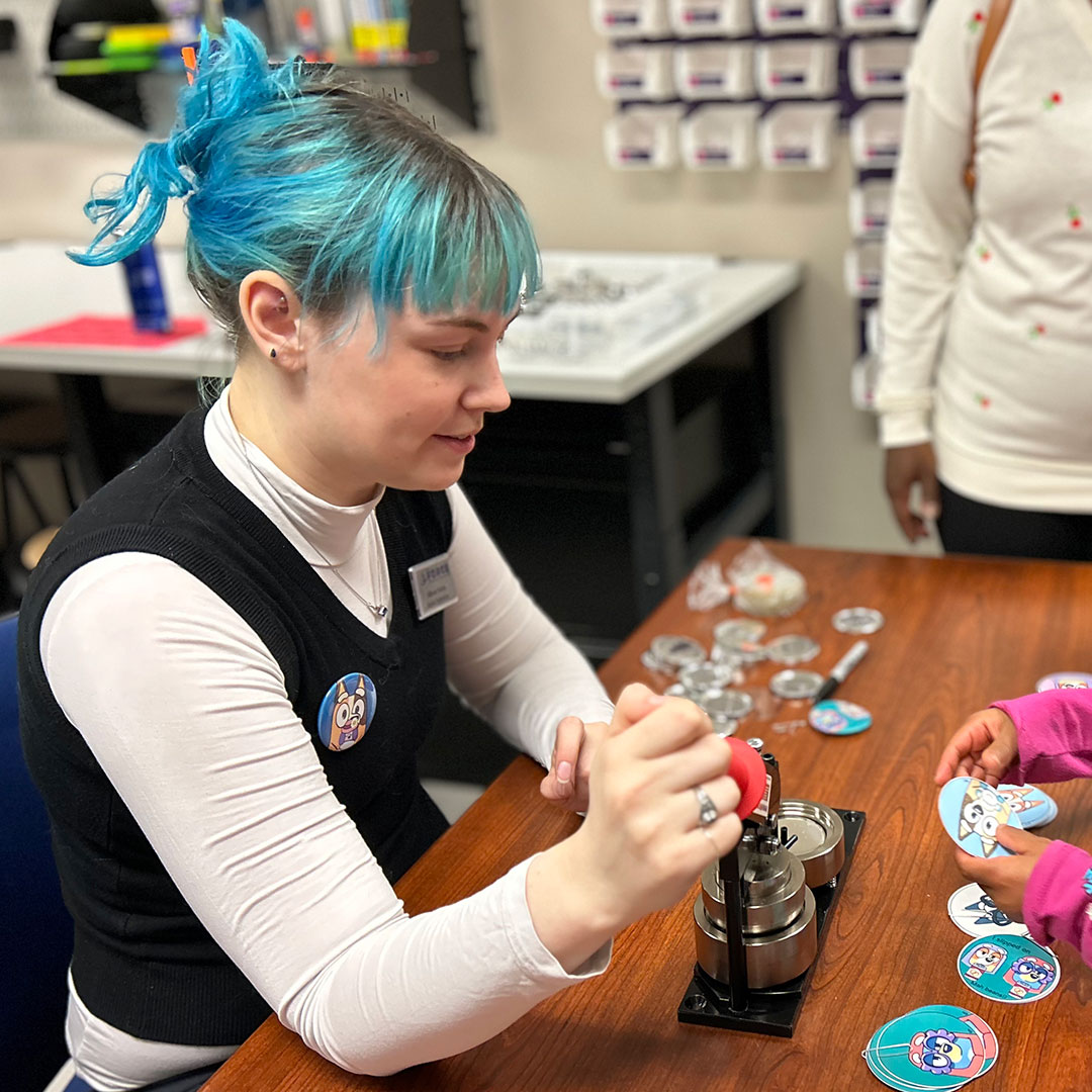 Peterson SFB Library employee making buttons
